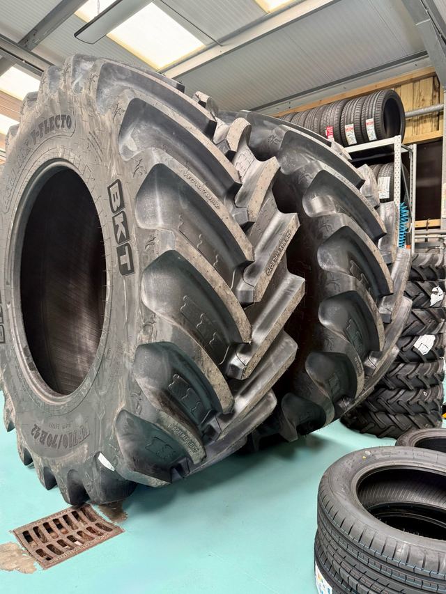Large BKT agricultural tyres standing on the workshop floor beside the racks