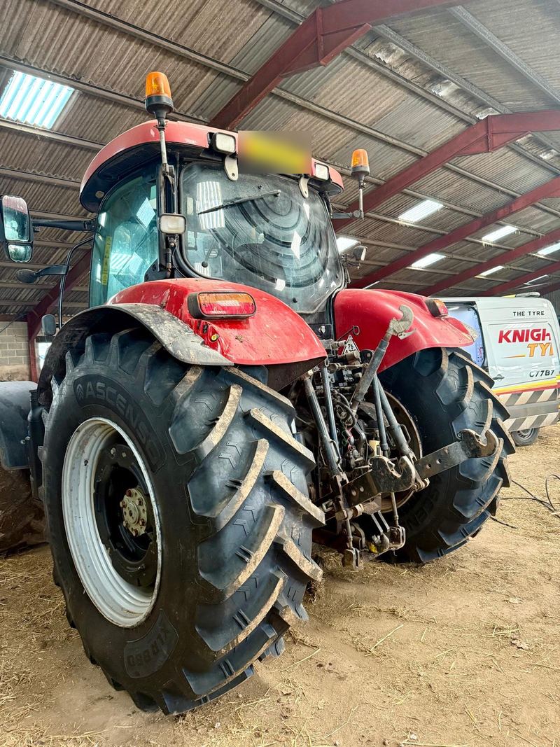 A red Case tractor in a barn on new Ascenso rear tyres, the Knightcott van parked behind