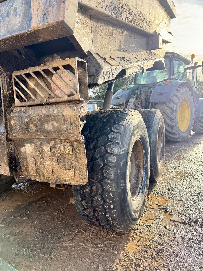 The same tipping trailer's wheels with deep-tread tyres on, a John Deere tractor behind