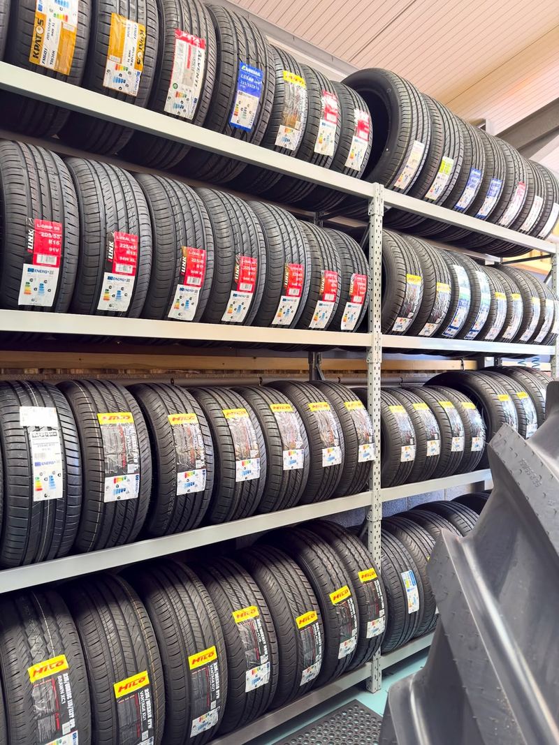 Rows of new car and van tyres on the racks at the tyre centre, labels facing out